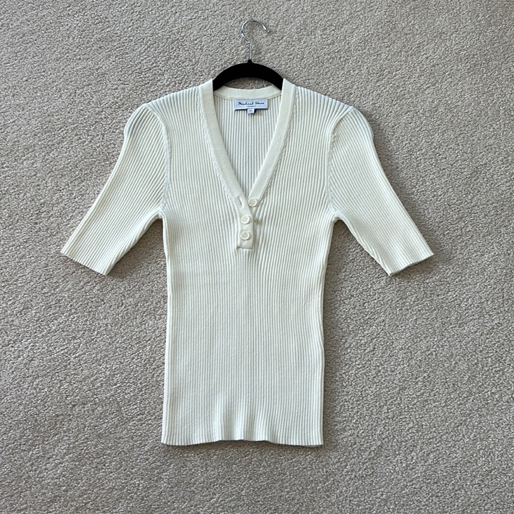3/4 sleeve, three button henley.  Generous XS lots of stretch.  Michael Stars